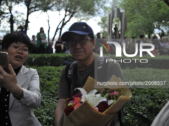 A father put flowers waiting in front of the school where their students are attending the China's annual national college entrance examinat...