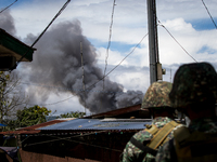 Philippine marines look at smoke following an airstrikes by Philippine Air Force in Marawi, southern Philippines on June 9, 2017. Philippine...