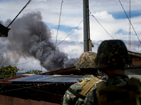 Philippine marines look at smoke following an airstrikes by Philippine Air Force in Marawi, southern Philippines on June 9, 2017. Philippine...