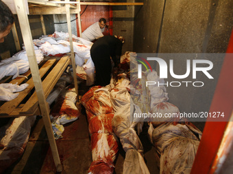 A A Palestinian relatives stand among bodies in a stored vegetable refrigerator in Rafah, in the southern Gaza Strip on August 2, 2014. A fr...