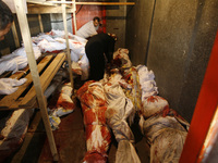 A A Palestinian relatives stand among bodies in a stored vegetable refrigerator in Rafah, in the southern Gaza Strip on August 2, 2014. A fr...