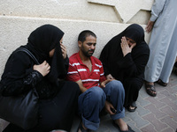 A Palestinian relatives mourn on one of their relatives at the al-Kuwaiti hospital a after an Israeli air strike in Rafah, in the southern G...