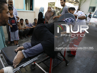 A wounded Palestinian woman arrives at the al-Kuwaiti hospital a after an Israeli air strike in Rafah, in the southern Gaza Strip on August...