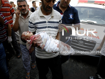 Palestinian relatives carry the body of two month old Noor al-Saidy, killed during attacks on the Gaza Strip, during her funeral in Rafah, i...