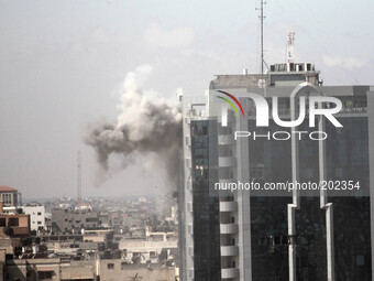 Smoke rises from Al Zafer tower apartment damaged by an Israeli strike in Gaza City . on August 3, 2014 as the Israeli-Hamas conflict enters...
