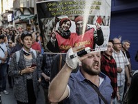 A protester show a cardboard of sacked academic Nuriye Gulmen and primary school teacher Semih Ozakca, who were arrested by a court decision...