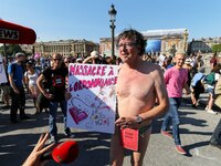 A protester in briefs holds a placard during a demonstration called by the collective 