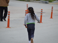 A Syrian refugee girl runs on the road on World Refugee Day in Ankara, Turkey on June 20, 2017. The day is internationally observed on June...