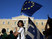 A woman holds a EU flag taking part to a rally organized by the Paraitithite (Resign) movement, at Syntagma Square, central Athens calling f...