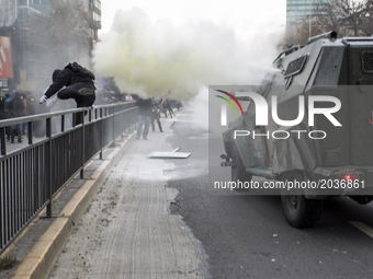 A protester runs away from tear gas thrown from an riot police vehicle
Led by the Confederation of Chilean Students (CONFECH), the march fo...