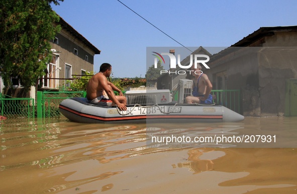 People try to save belongings, animals and pets in the flooded town of Mizia north-east of the Bulgarian capital Sofia , Wednesday, Aug, 06,...