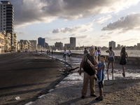 Several people walk the Malecón in Havana in May 2017
 (