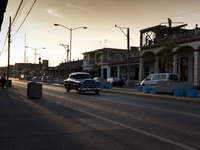 An old car crosses the main street of Pinar del Río, Cuba. Men work in the construction.
 (