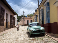 A girl descends to the street on her bicycle in Trinidad Cuba. (