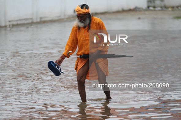 A Sadhu cross flood waters street after heavy rains in Pushkar, India, on August 8, 2014. 