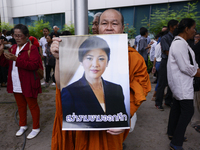 Supporters of ousted former Thai prime minister Yingluck Shinawatra holds a picture Yingluck Shinawatra, while waiting for her arrival at th...