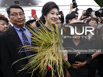 Ousted former Thai Prime Minister Yingluck Shinawatra greets supporters as she arrives at the Supreme Court for a trial on criminal negligen...