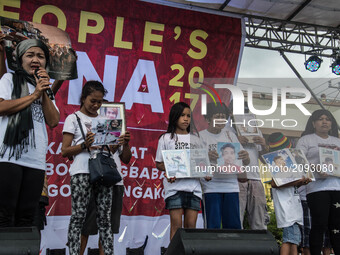 Families of the victims of the ongoing war on drugs and extra-judicial killings hold portraits of their dead loved ones on stage. President...