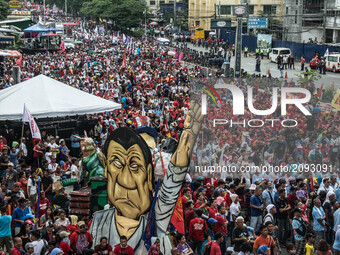 An image of President Rodrigo Duterte stands among thousands of protesters to air their concerns. President Duterte delivers his second Stat...