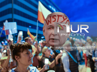 A lady holds an image of PiS Chairman Jaroslaw Kaczynski's face withthe word 'Shame' written on his forehead, during an anti-government cand...
