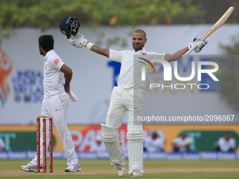 Indian cricketer Shikhar Dhawan celebrates after scoring 100 runs during the 1st Day's play in the 1st Test match between Sri Lanka and Indi...