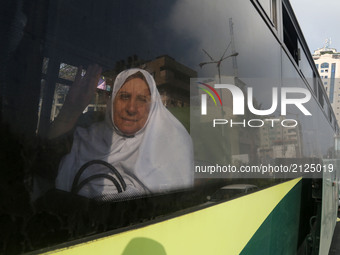 A Palestinian woman is seen through a window en route to the Rafah border between the Gaza Strip and Egypt before leaving for the annual haj...