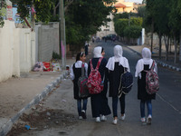 Palestinian schoolgirls chat as they head to school on the first day of a new academic year,  in Gaza City on August 23, 2017  (