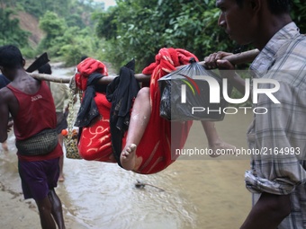 A Rohingya child is carried on a sling while his family walk throuh hill after crossing the border into Bangladesh near Cox's Bazar's Teknaf...