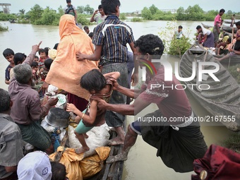 Rohingya refugees get on a boat to cross the border into Bangladesh at Mongdaw, Myanmar on September 6, 2017.  Rohingya are a Muslim ethnic...