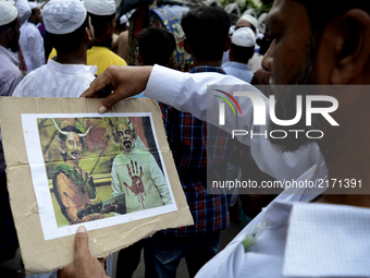 Bangladeshi muslim protester holding a placard during a protest rally against the persecution of Rohingya Muslims in Myanmar, after Friday p...
