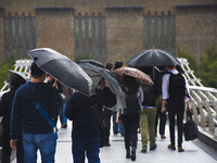People are seen walking on Millennium Bridge holding umbrellas, due to the heavy rain, London on September 8, 2017.  (