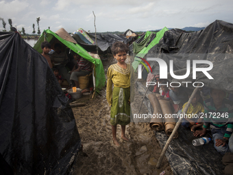 A Rohingya ethnic minority girl pose for a photo at a  temporary makeshift camp after crossing over from Myanmar into the Bangladesh side of...