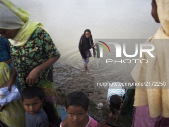 Rohingya ethnic minority elderly  washing her cloths at a temporary makeshift camp after crossing over from Myanmar into the Bangladesh side...