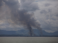 A fire seen at Shilpara of Myanmar side, near Cox's Bazar's Shah Purir Dip, Satarday, Sept. 9, 2017. Tens of thousands more people have cros...