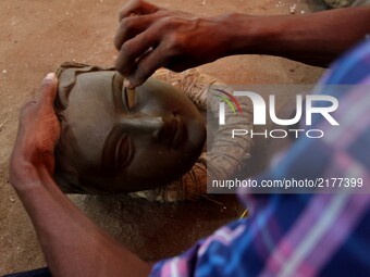 A traditional image maker or artist is busy to polish a clay portraits of goddess Durga ahead of the Durga puja festival in the eastern Indi...