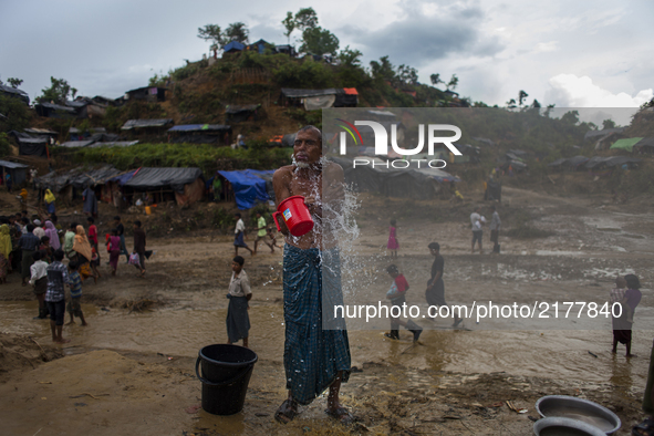 Rohingya Muslim refugees are taking shower at a temporary makeshift shelters after crossing over from Myanmar into the Bangladesh side of th...