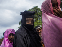 Rohingya Muslim refugees wait for medical support near a camp at a temporary makeshift shelters after crossing over from Myanmar into the Ba...