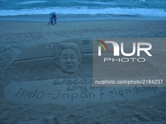 Indian sand artist Sudarsan Pattnaik creating a sand sculpture to welcome Japanese prime minister with message 