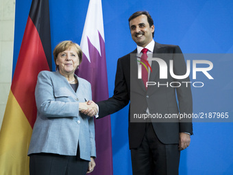 German Chancellor Angela Merkel and Emir of Qatar Sheikh Tamim bin Hamad Al Thani shake hands at the end of a news conference at the Chancel...