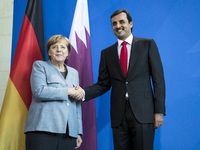 German Chancellor Angela Merkel and Emir of Qatar Sheikh Tamim bin Hamad Al Thani shake hands at the end of a news conference at the Chancel...