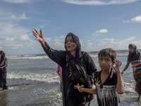 Rohingya refugees walk to the shore of Bangladesh after crossing the Naf river by boat. Shahpirer Dip, Teknaf, Bangladesh; September 14, 201...
