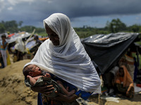 A Rohingya woman tries to cover her 4 days new born granddaughter from the sun near a makeshift camp in Ukhiiya, Bangladesh 14 September 201...
