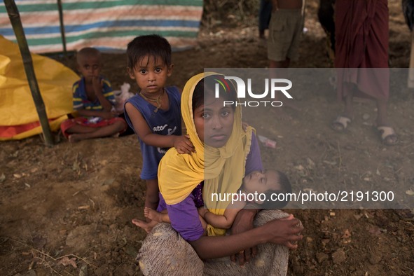 Rohingya woman with her child sit in her makeshift tent at the Thenkhali refugee camp in Cox’s Bazar, Bangladesh September 16, 2017. Around...