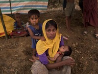 Rohingya woman with her child sit in her makeshift tent at the Thenkhali refugee camp in Cox’s Bazar, Bangladesh September 16, 2017. Around...