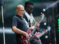 Guitarist Izo Diop (L) of French band Trust performs at the Festival of Humanity (Fete de l'Humanite), a political event and music festival...