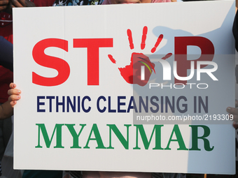 Muslim girl holds a sign saying 'Stop ethnic cleansing in Myanmar' as hundreds of demonstrators marched to protest against the violence agai...