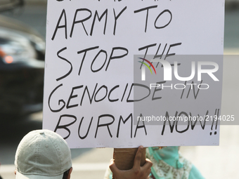 Protestor holds a sign saying 'Send the Canadian army to stop the genocide in Burma now' as hundreds of demonstrators marched to protest aga...