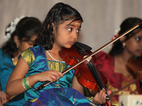 Youth perform traditional Carnatic classical songs on the violin during the Thiruvaiyaru Music and Dance Festival held in Toronto, Ontario,...
