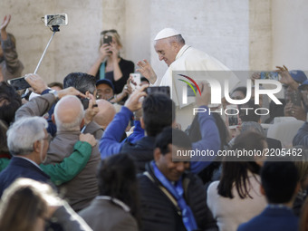 Pope Francis greets the faithful as he arrives to celebrate his Weekly General Audience in St. Peter's Square in Vatican City, Vatican on Se...