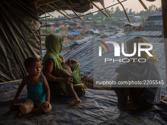 A Rohingya family sits inside their half built shelter in Balikhali refugee camp, Cox’s Bazar, Bangladesh. September 16, 2017. (